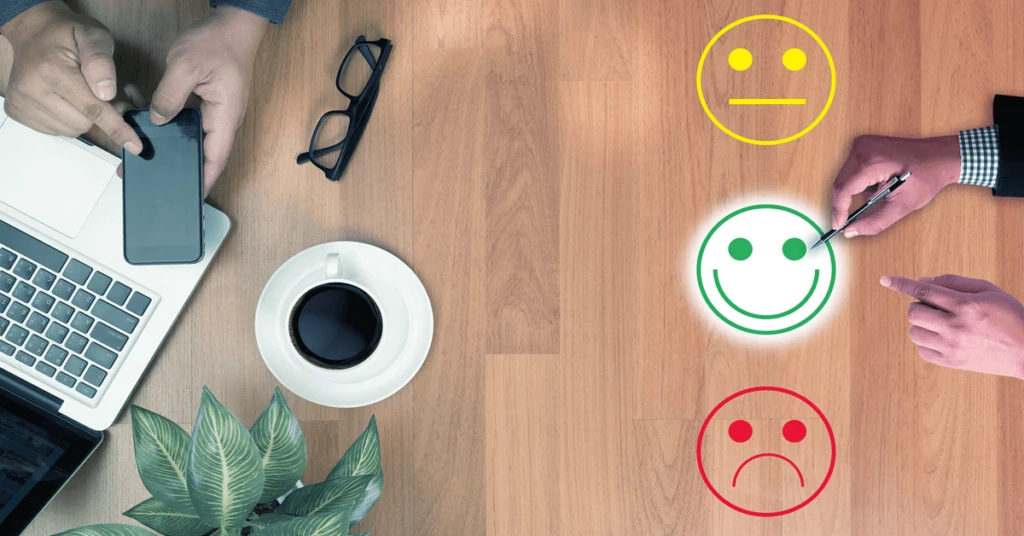 Imagen de evaluación de satisfacción en el entorno laboral, con símbolos de sonrisa, neutralidad y tristeza, representando diferentes niveles de retroalimentación.